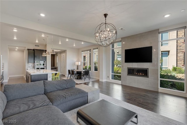 11280 Granite Ridge Dr Unit 1009, Las Vegas, NV 89135 - living room featuring wood finished floors, a tile fireplace, recessed lighting, a chandelier, and baseboards