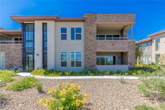 11280 Granite Ridge Dr Unit 1009, Las Vegas, NV 89135 - back of house featuring a balcony, stucco siding, brick siding, and stone siding
