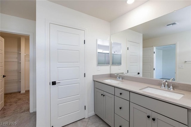 9086 Nostrand Ave, Las Vegas, NV 89148 - full bathroom with double vanity, tile patterned flooring, a walk in closet, and baseboards