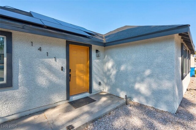 1411 Norman Ave, Las Vegas, NV 89104 - doorway to property featuring stucco siding and roof mounted solar panels