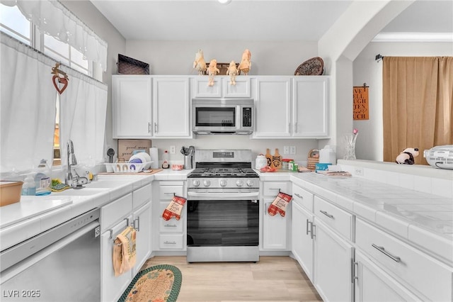 1011 Dancing Vines Ave, Las Vegas, NV 89183 - kitchen featuring appliances with stainless steel finishes, white cabinetry, and light wood finished floors