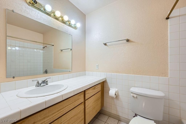 6766 Sebring St, Las Vegas, NV 89103 - full bath featuring vanity, a shower, tile patterned flooring, a textured wall, and tile walls