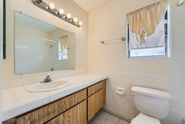 6766 Sebring St, Las Vegas, NV 89103 - bathroom featuring vanity, tile patterned flooring, tile walls, a wainscoted wall, and a shower