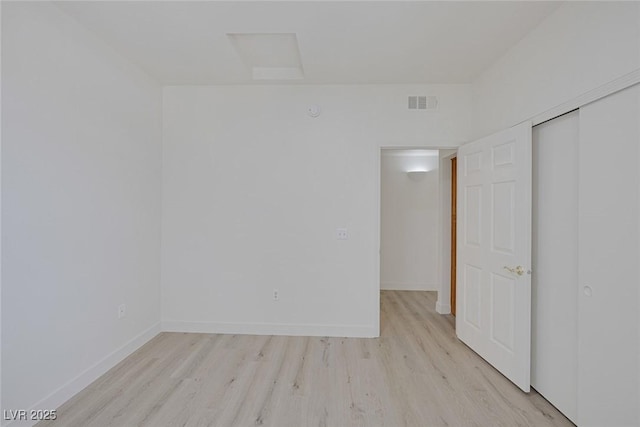 1830 N Buffalo Dr Unit 2024, Las Vegas, NV 89128 - unfurnished bedroom with light wood-style flooring, attic access, baseboards, and a closet