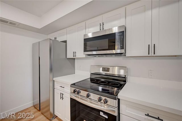 8412 Mulcahy Ave, Las Vegas, NV 89145 - kitchen with appliances with stainless steel finishes, light countertops, white cabinets, light wood-style floors, and baseboards