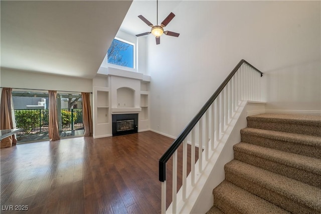 5256 Harvest Breeze Rd, Las Vegas, NV 89118 - stairs with high vaulted ceiling, plenty of natural light, ceiling fan, a glass covered fireplace, and wood finished floors