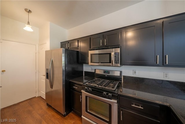 5256 Harvest Breeze Rd, Las Vegas, NV 89118 - kitchen featuring appliances with stainless steel finishes, dark countertops, dark wood-style floors, and hanging light fixtures
