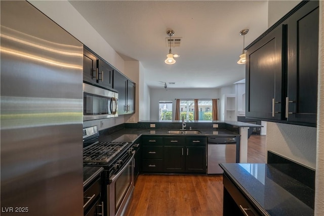 5256 Harvest Breeze Rd, Las Vegas, NV 89118 - kitchen featuring stainless steel appliances, a sink, dark cabinets, and a peninsula