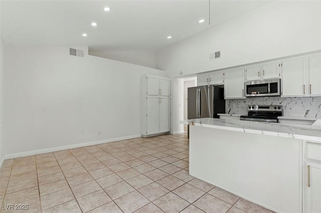 9116 Cypress Point Way, Las Vegas, NV 89117 - kitchen featuring stainless steel appliances, lofted ceiling, decorative backsplash, recessed lighting, and white cabinets
