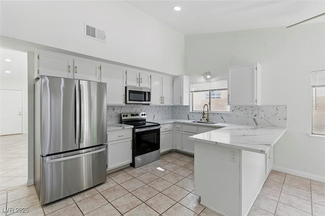 9116 Cypress Point Way, Las Vegas, NV 89117 - kitchen with appliances with stainless steel finishes, a peninsula, tasteful backsplash, a sink, and white cabinetry