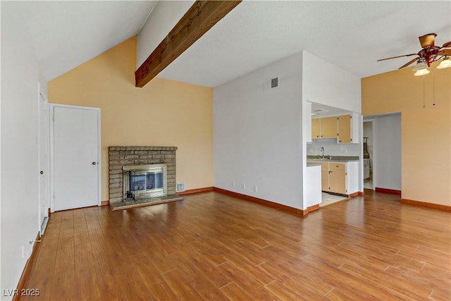 4391 Gannet Cir Unit 16, Las Vegas, NV 89103 - unfurnished living room featuring ceiling fan, a sink, light wood finished floors, a fireplace, and baseboards