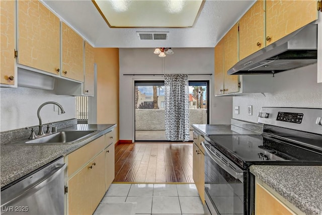 4391 Gannet Cir Unit 16, Las Vegas, NV 89103 - kitchen with appliances with stainless steel finishes, a sink, under cabinet range hood, light wood-type flooring, and dark countertops