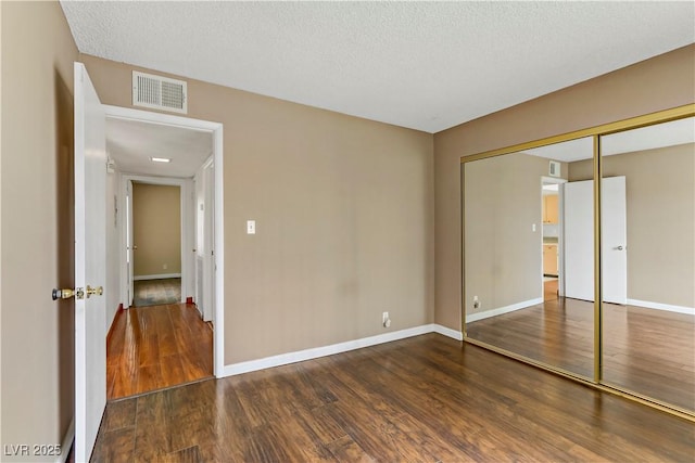 4391 Gannet Cir Unit 16, Las Vegas, NV 89103 - unfurnished bedroom featuring wood finished floors, a closet, baseboards, and a textured ceiling