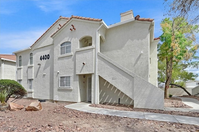 4400 W Lake Mead Blvd Unit 101, Las Vegas, NV 89108 - view of front of house with stucco siding, a chimney, and a tile roof
