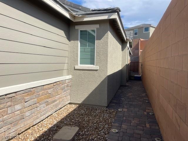 3447 SW Covilha Ln, Henderson, NV 89044 - view of side of home featuring stucco siding and a gate