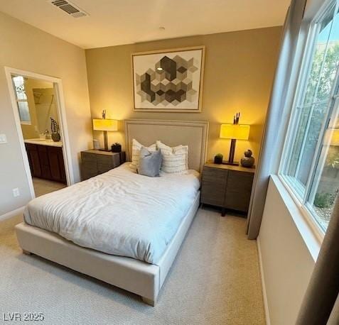 3447 SW Covilha Ln, Henderson, NV 89044 - bedroom with light colored carpet, ensuite bath, and baseboards