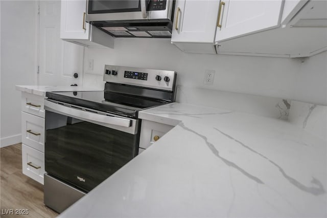 2711 Sesame Dr, Las Vegas, NV 89142 - kitchen with appliances with stainless steel finishes, white cabinets, light wood-type flooring, and light stone counters