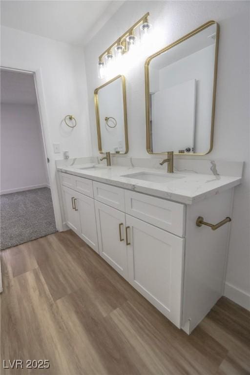 2711 Sesame Dr, Las Vegas, NV 89142 - bathroom with wood finished floors, double vanity, and baseboards