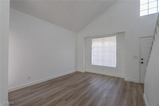2711 Sesame Dr, Las Vegas, NV 89142 - empty room featuring wood finished floors, high vaulted ceiling, plenty of natural light, and baseboards