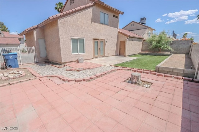 2711 Sesame Dr, Las Vegas, NV 89142 - back of property with a patio area, a tile roof, stucco siding, and an outdoor fire pit
