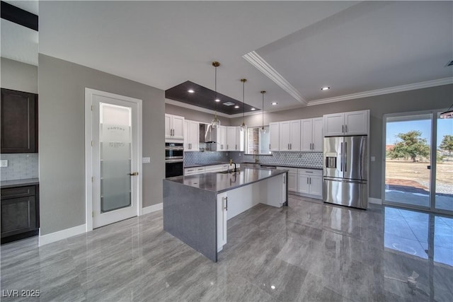 2650 Underbrush Ave, Pahrump, NV 89048 - kitchen featuring stainless steel appliances, ornamental molding, tasteful backsplash, wall chimney range hood, and dark countertops