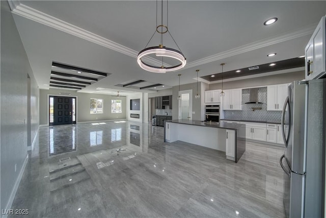 2650 Underbrush Ave, Pahrump, NV 89048 - kitchen featuring stainless steel appliances, open floor plan, wall chimney range hood, ornamental molding, and dark countertops