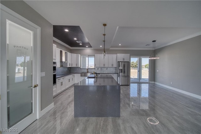 2650 Underbrush Ave, Pahrump, NV 89048 - kitchen featuring stainless steel appliances, backsplash, white cabinets, crown molding, and a center island
