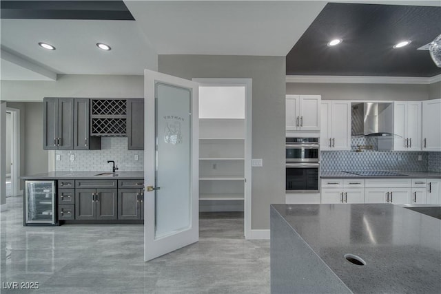 2650 Underbrush Ave, Pahrump, NV 89048 - kitchen with wall chimney range hood, wine cooler, double oven, backsplash, and black electric stovetop