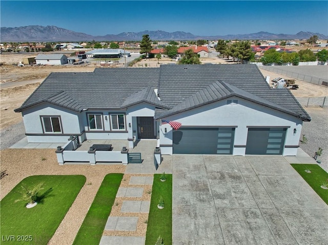 2650 Underbrush Ave, Pahrump, NV 89048 - ranch-style house featuring driveway, a garage, a mountain view, and a tiled roof