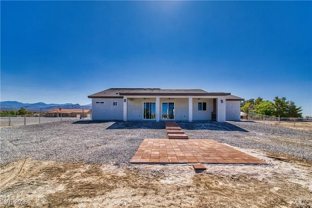 2650 Underbrush Ave, Pahrump, NV 89048 - rear view of property featuring a ceiling fan, a patio, a fenced backyard, a mountain view, and stucco siding