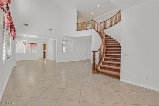 3689 Bufflehead St, Las Vegas, NV 89122 - unfurnished living room featuring light tile patterned flooring, a high ceiling, recessed lighting, stairs, and baseboards