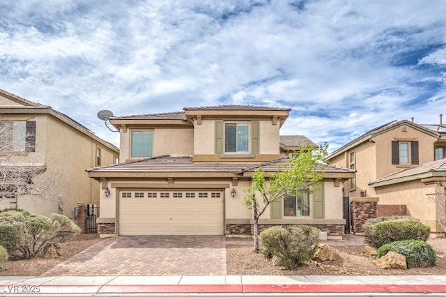3725 Moonshine Falls Ave, North Las Vegas, NV 89085 - view of front of home with a garage, decorative driveway, stucco siding, a tiled roof, and stone siding