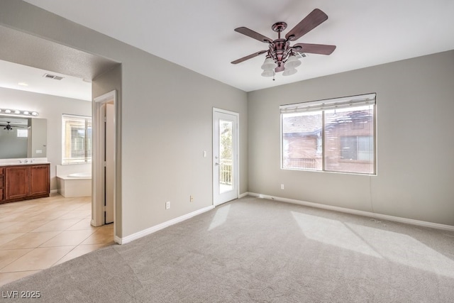 3725 Moonshine Falls Ave, North Las Vegas, NV 89085 - unfurnished bedroom featuring access to outside, light colored carpet, ensuite bathroom, baseboards, and light tile patterned floors