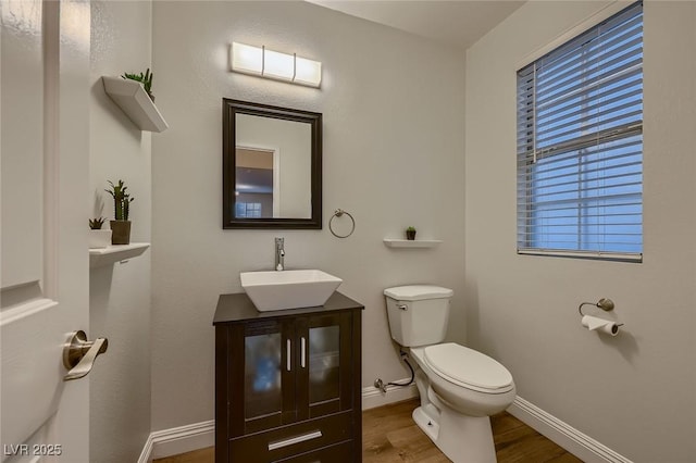672 Solitude Point Ave, Henderson, NV 89012 - half bathroom featuring wood finished floors, toilet, vanity, and baseboards