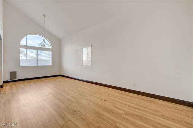 7528 Golden Yucca Dr, Las Vegas, NV 89147 - unfurnished room with light wood-type flooring, high vaulted ceiling, and a chandelier