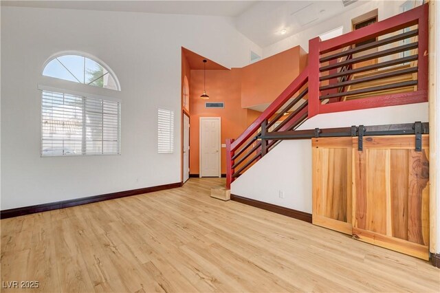 7528 Golden Yucca Dr, Las Vegas, NV 89147 - unfurnished living room featuring stairway, wood finished floors, and high vaulted ceiling