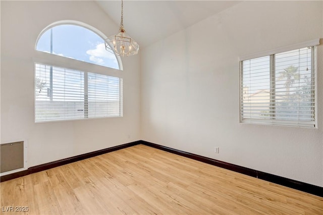 7528 Golden Yucca Dr, Las Vegas, NV 89147 - empty room with a chandelier, wood finished floors, and high vaulted ceiling