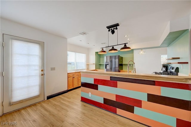 7528 Golden Yucca Dr, Las Vegas, NV 89147 - kitchen with stainless steel fridge, open shelves, light wood-style floors, pendant lighting, and light countertops