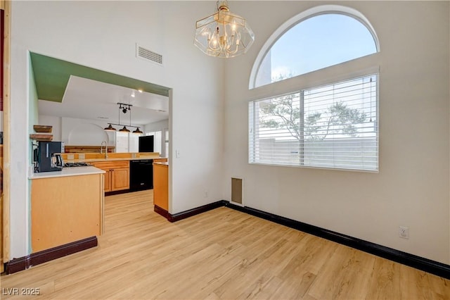 7528 Golden Yucca Dr, Las Vegas, NV 89147 - unfurnished dining area featuring light wood-style floors, a chandelier, and a towering ceiling