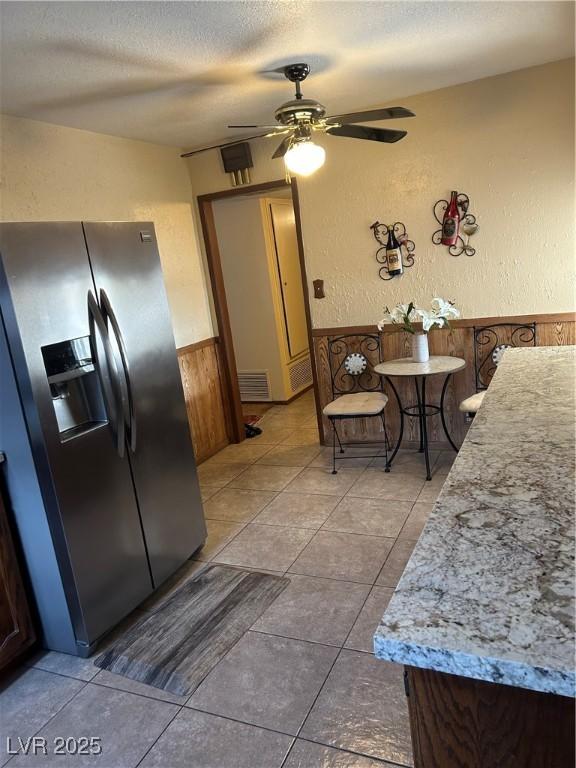 712 Donner St, Las Vegas, NV 89107 - kitchen with stainless steel fridge, ceiling fan, a wainscoted wall, a textured ceiling, and a textured wall