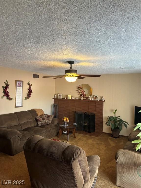 712 Donner St, Las Vegas, NV 89107 - carpeted living area featuring ceiling fan, a textured ceiling, and a brick fireplace