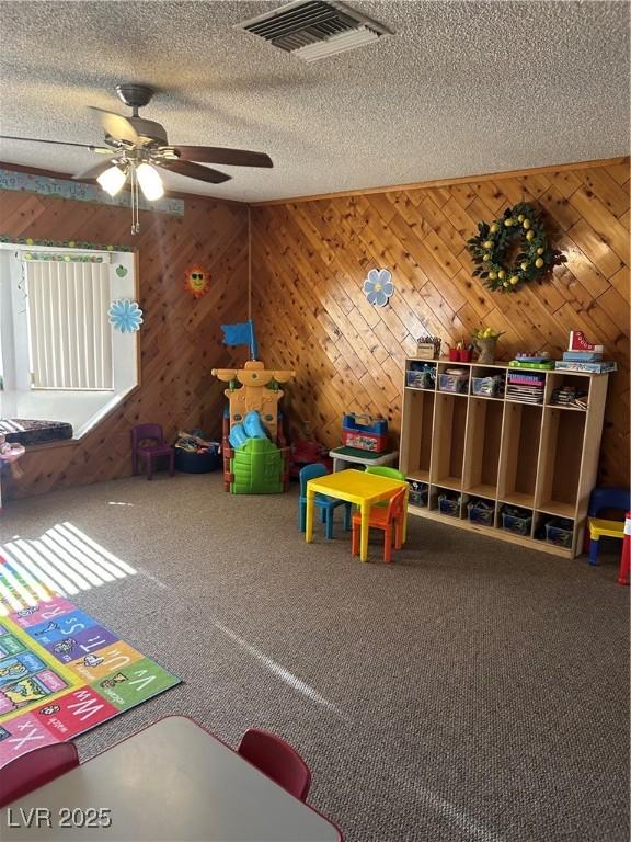 712 Donner St, Las Vegas, NV 89107 - recreation room with ceiling fan, a textured ceiling, carpet flooring, and wood walls