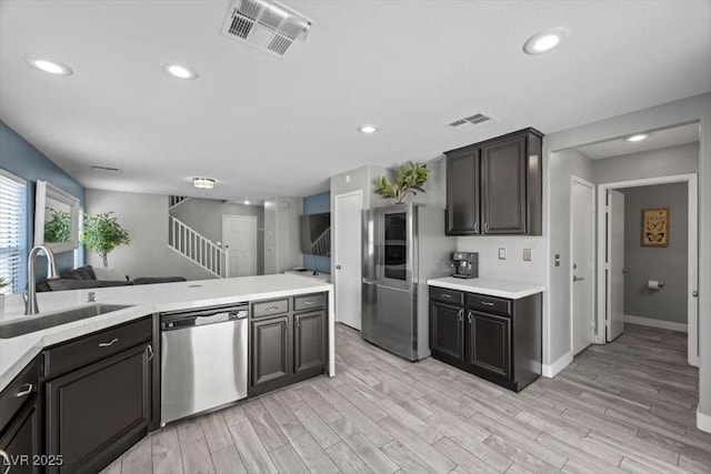 106 Basketflower Ct, Las Vegas, NV 89183 - kitchen featuring appliances with stainless steel finishes, a sink, light countertops, light wood-type flooring, and baseboards