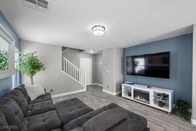 106 Basketflower Ct, Las Vegas, NV 89183 - living area with stairway, wood finished floors, baseboards, and a lit fireplace