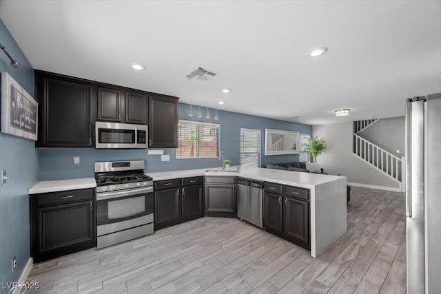 106 Basketflower Ct, Las Vegas, NV 89183 - kitchen with stainless steel appliances, a peninsula, light countertops, open floor plan, and a sink