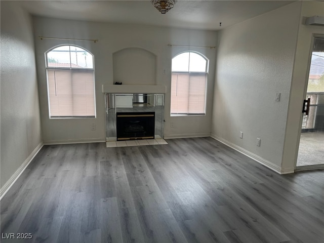 4555 E Sahara Ave Unit 288, Las Vegas, NV 89104 - unfurnished living room featuring wood finished floors, baseboards, and a high end fireplace
