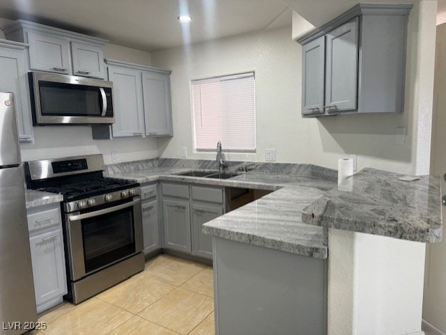 4555 E Sahara Ave Unit 288, Las Vegas, NV 89104 - kitchen with appliances with stainless steel finishes, gray cabinets, a sink, and a peninsula