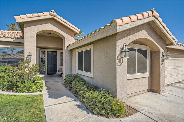 1609 Hidden Spring Dr, Las Vegas, NV 89117 - entrance to property featuring a tiled roof, stucco siding, and a garage