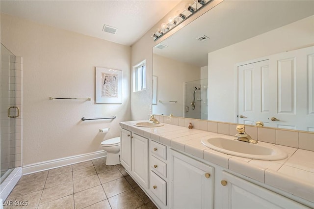 1609 Hidden Spring Dr, Las Vegas, NV 89117 - full bath featuring baseboards, a stall shower, double vanity, toilet, and tile patterned flooring
