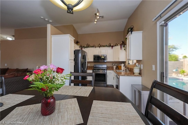 3913 Lilac Haze St, Las Vegas, NV 89147 - kitchen with appliances with stainless steel finishes, a sink, lofted ceiling, white cabinetry, and open floor plan